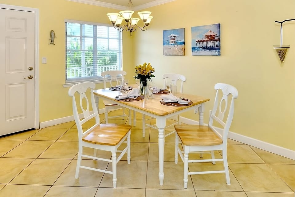 Gather for relaxed meals under warm lighting and coastal art.