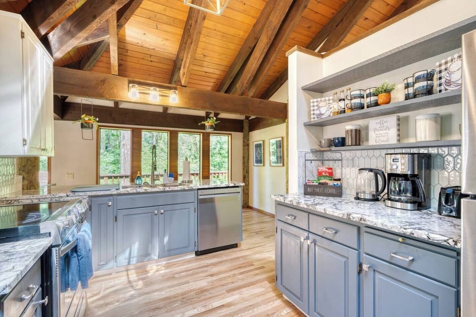 Whether you’re whipping up a meal or enjoying a coffee, this kitchen is the heart of the cabin, featuring modern appliances like a new electric stove, dishwasher, and refrigerator, along with updated cabinet colors, gorgeous new granite countertops, and a stylish picket tile backsplash.
