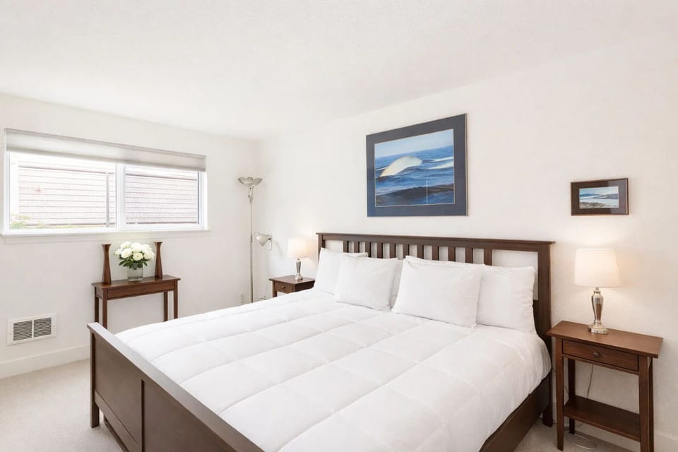 Main Bedroom: Bright and inviting retreat with king bed, modern decor, and serene ocean-inspired art.
