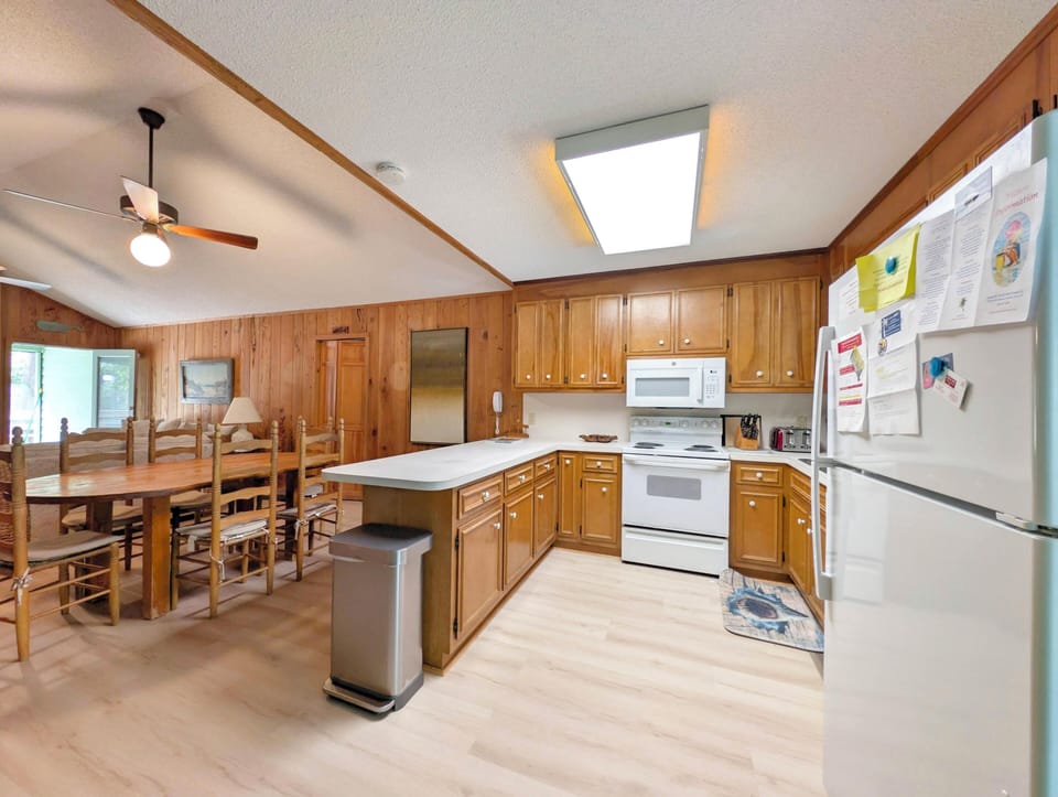 Your spacious open-concept kitchen and dining area features warm wood cabinetry, full-size appliances, and a large dining table perfect for gathering together after a day of adventure.