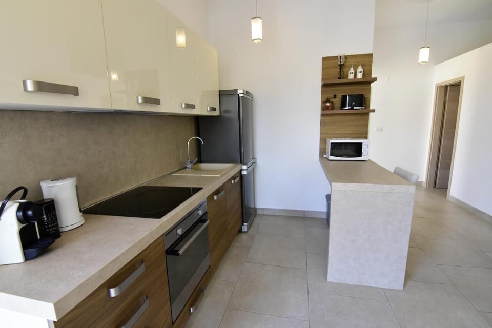 The kitchen equipped with a microwave, coffee maker, kettle, toaster, oven