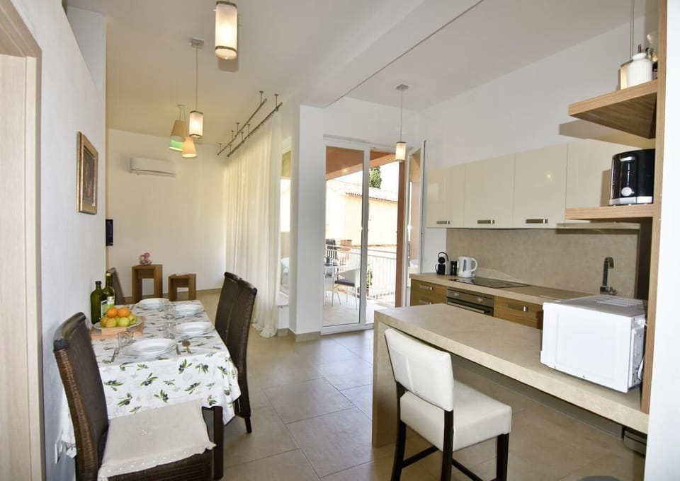 The living area with dining table, equipped kitchen and exit to the balcony.