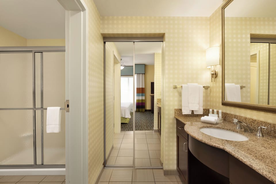 Refresh in a spotless bathroom with granite vanity and bright lighting.