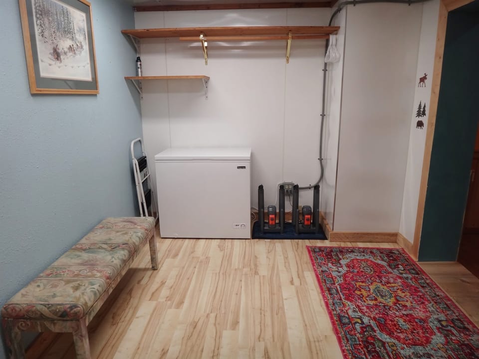 Mudroom has a chest freezer and two boot dryers.