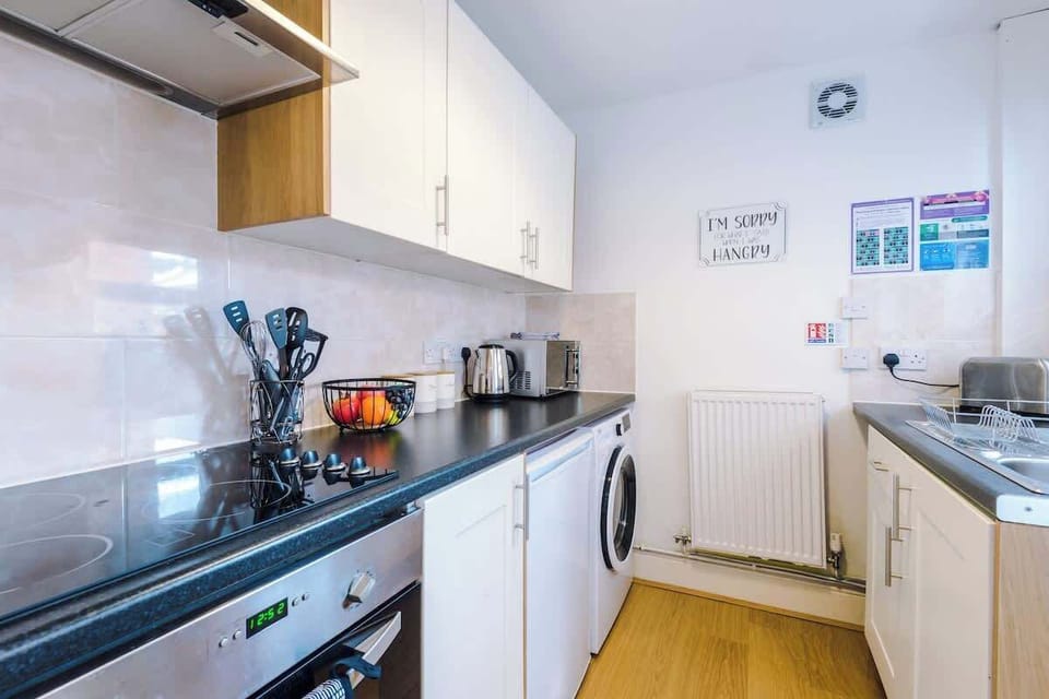 Fully equipped kitchen with an oven, hob, toaster, kettle, microwave and a washer/dryer.