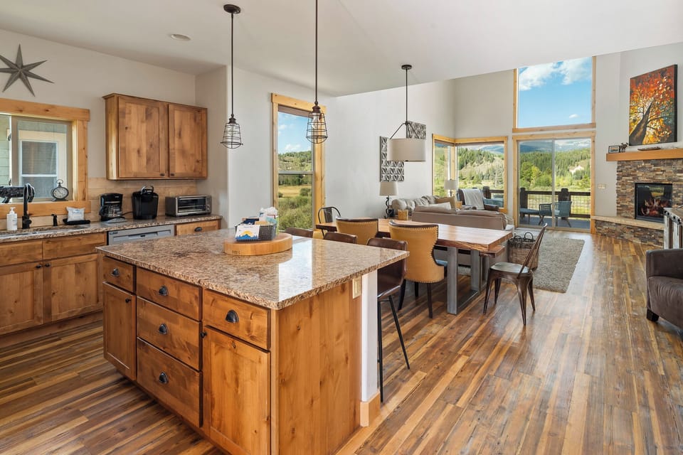 - Bright kitchen with granite island overlooking dining and living areas   - Open windows showcase mountain views while cooking or dining   - Vacation rental ideal for family meals and scenic getaways