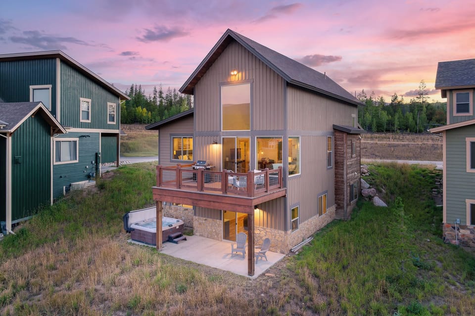 - Sunset view of mountain cabin exterior with tall windows glowing warmly   - Private deck and hot tub add charm for mountain stays   - Scenic rental home perfect for peaceful Colorado getaway