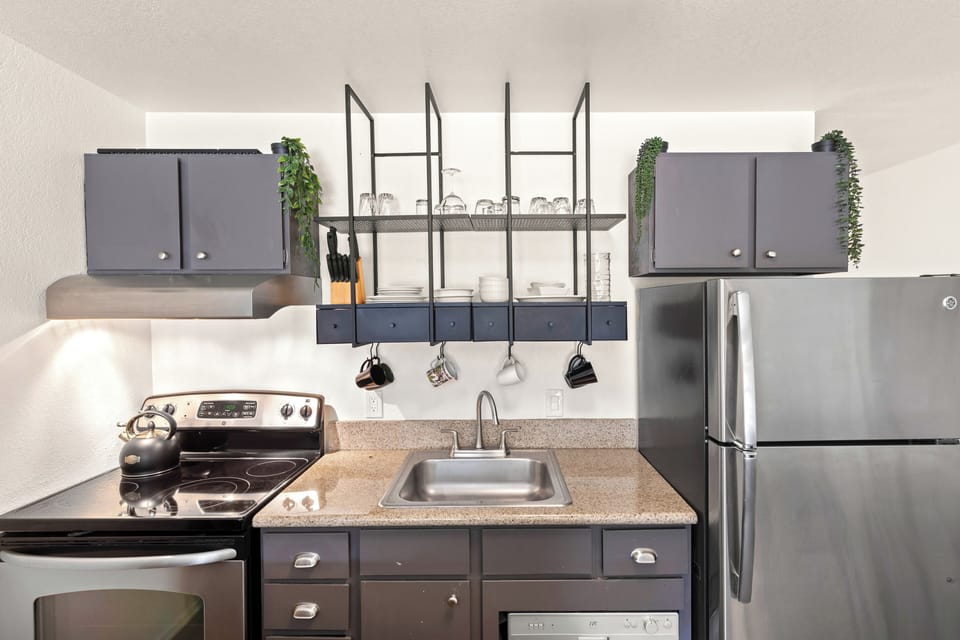 The kitchen has stainless steel appliances, and a wall mounted dish rack.