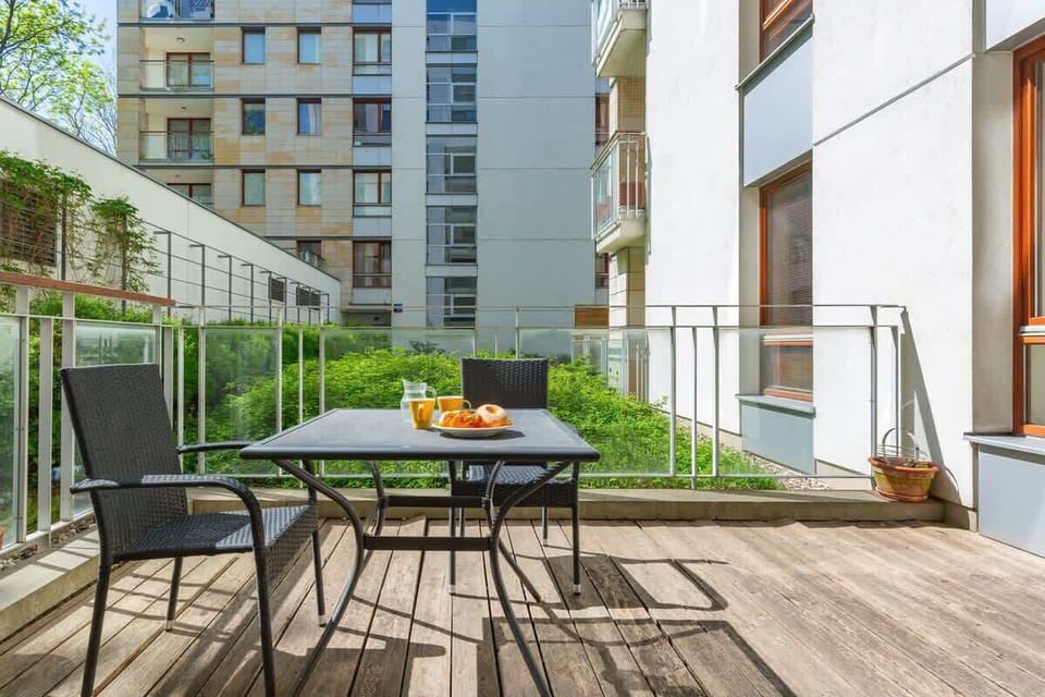 Furnished balcony with green surroundings. 