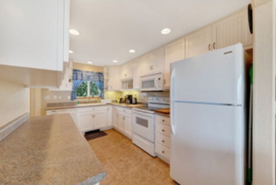 The kitchen is well stocked with utensils, dishes and cookware.