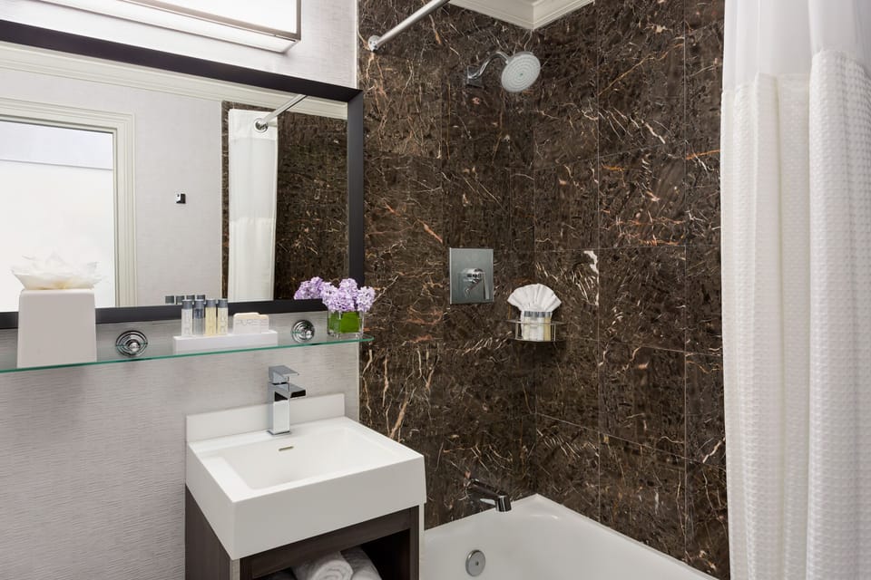 Refresh under a rain shower amid rich marble elegance.