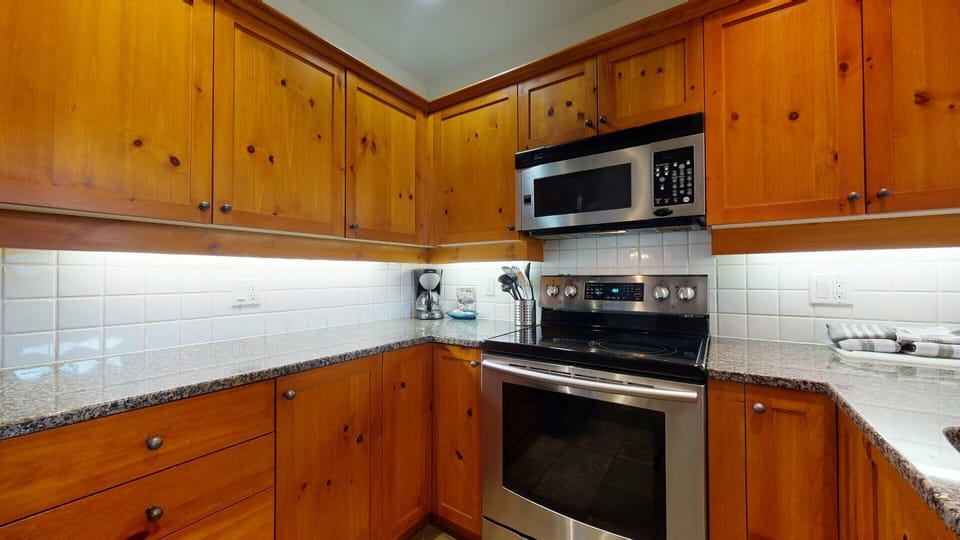 Kitchen with electric glass top stove and microwave