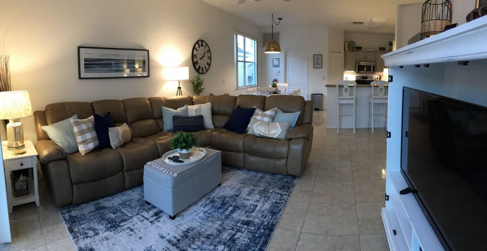 Family room with two recliners in leather sectional, large TV, PlayStation/games