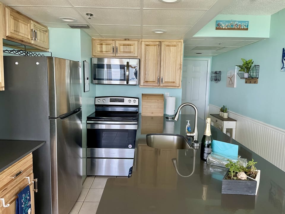 Fully equipped kitchen with stainless steel appliances and quartz countertops.