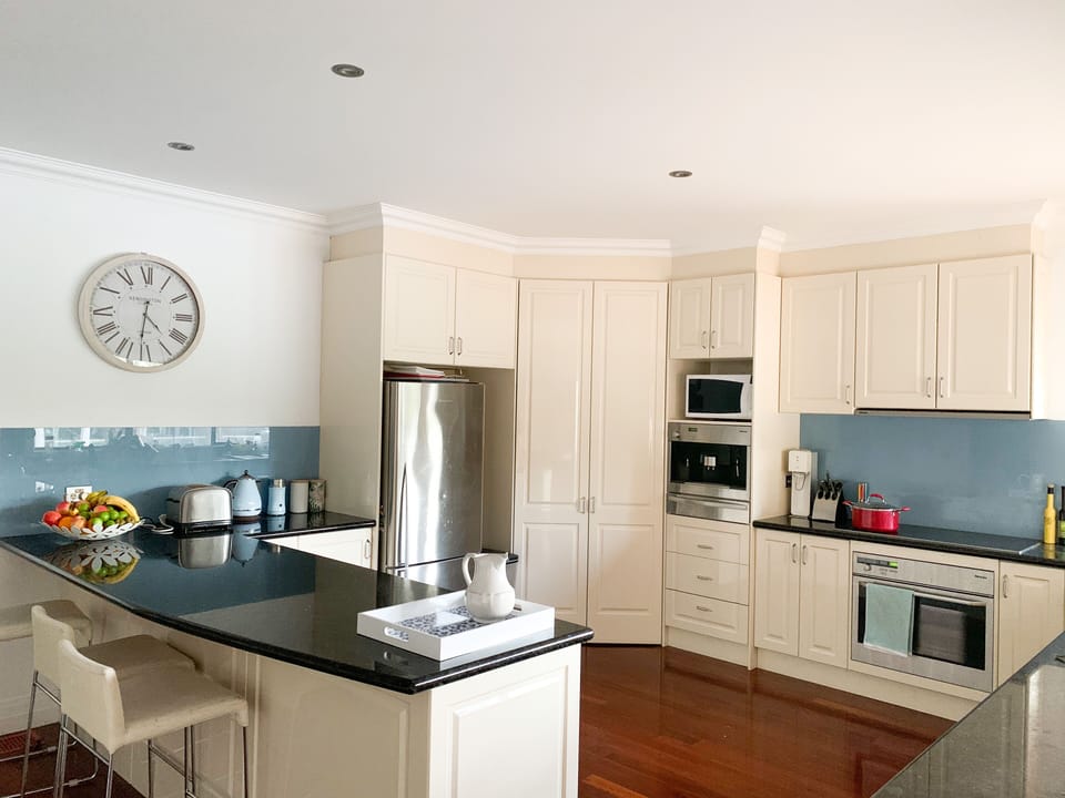 Kitchen with stone bench tops, Miele appliances and outlook to pool