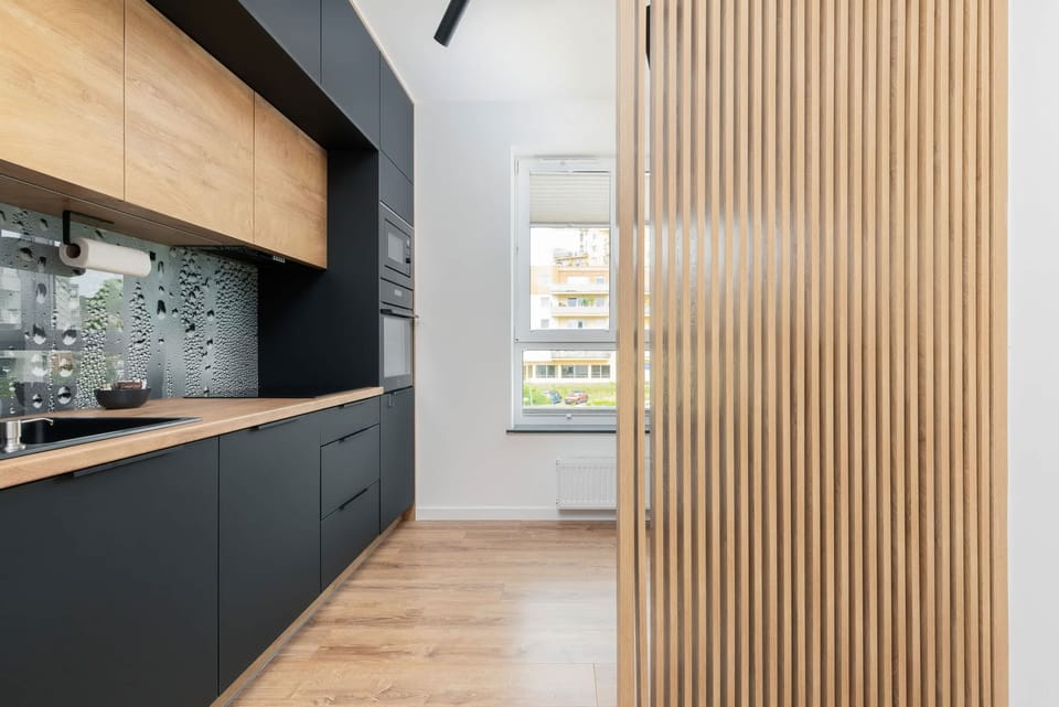 Well-equipped kitchen featuring modern black cabinetry, wooden countertops, and high-end appliances.