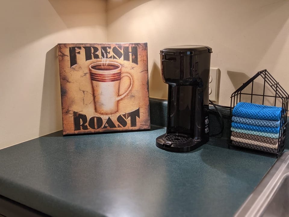 K-cup coffee maker w/ a variety of kcups, sweetners, creamers, & mugs provided