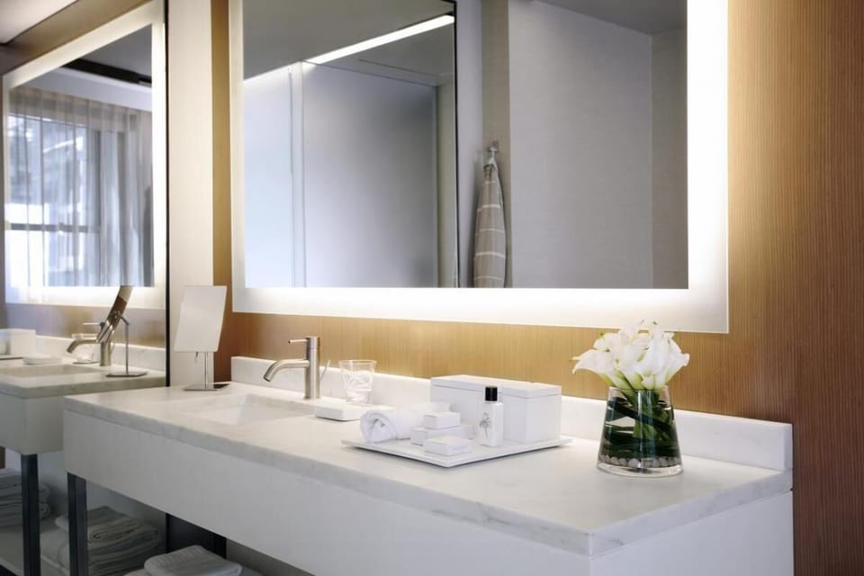Refresh effortlessly at the sleek double vanity with bright lighting.
