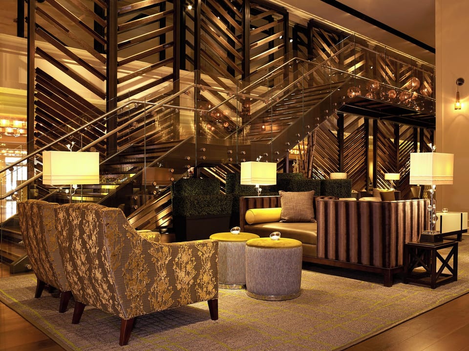 Unwind in a stylish lounge with warm, golden lighting.