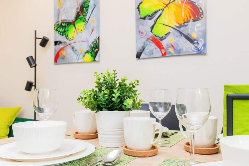 A closer look at the dining setup, highlighting tableware and decor with a view of the vibrant green curtains in the background.
