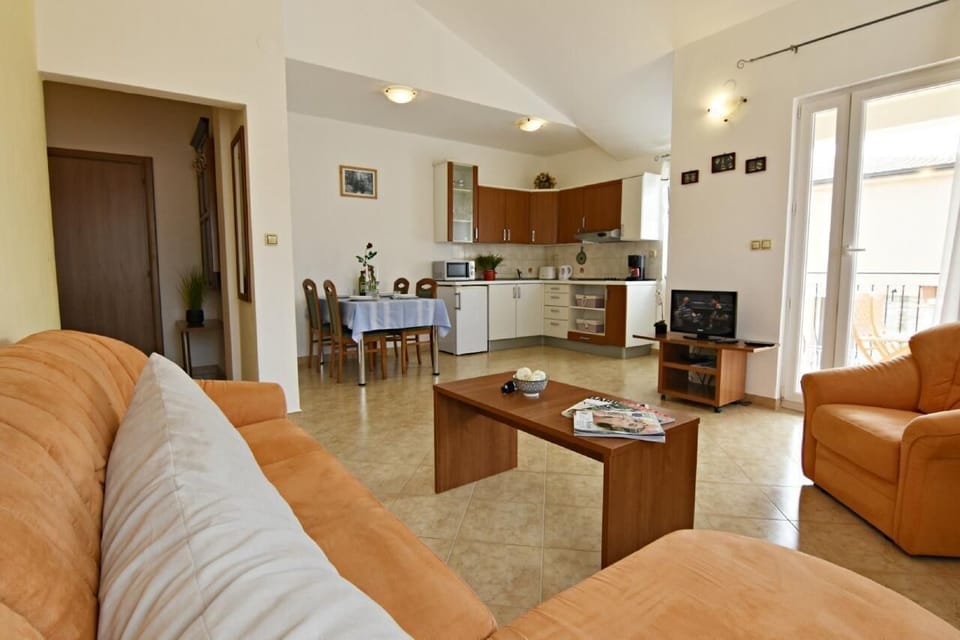 The living area with sofa bed, armchair, coffee table, satellite TV, dining area