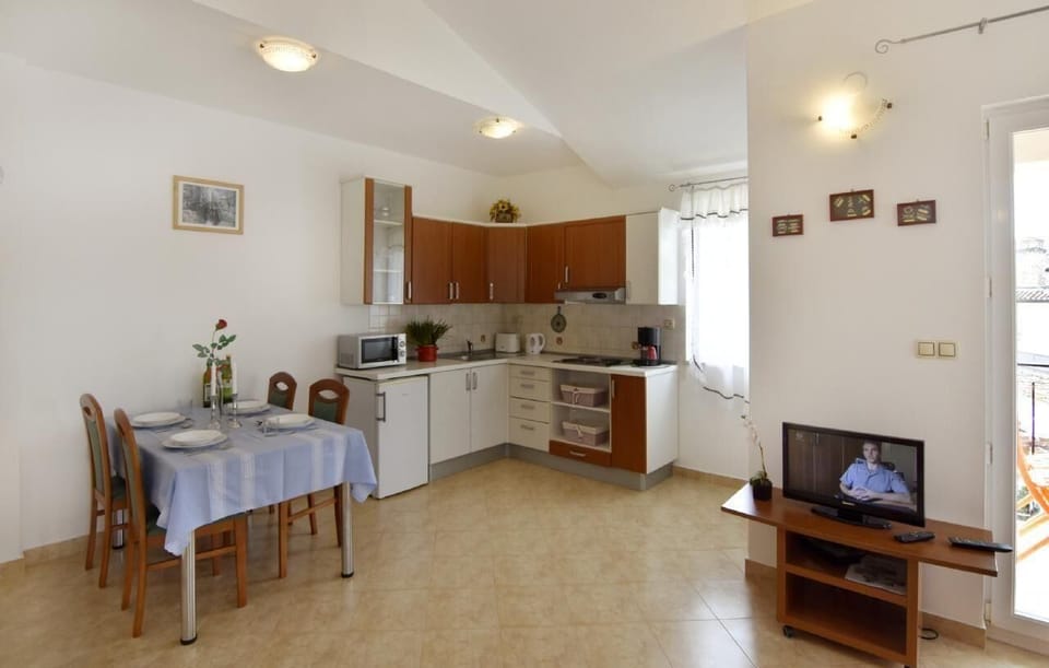 The dining area with table and chairs, kitchen equipped with microwave, refrigerator ...
