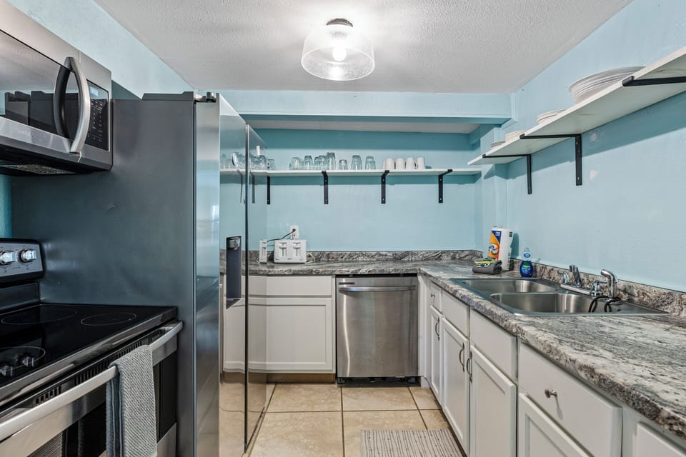 A fully equipped kitchen with granite countertops and stainless steel appliances.