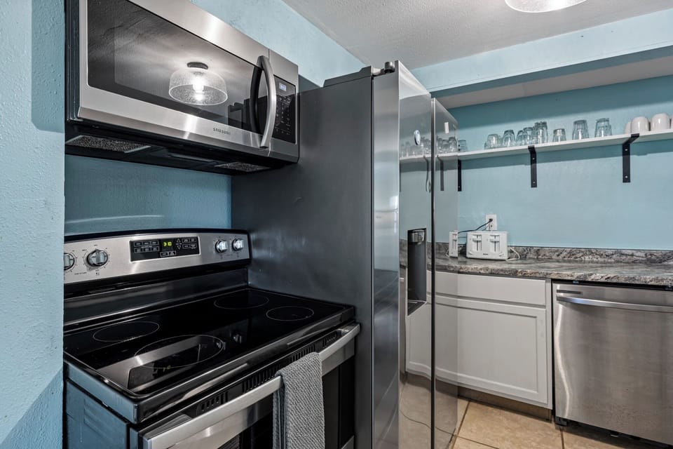 Historic Anchor at M (Studio) — a fully equipped galley kitchen with stainless steel appliances; the Trio has three kitchens in all.