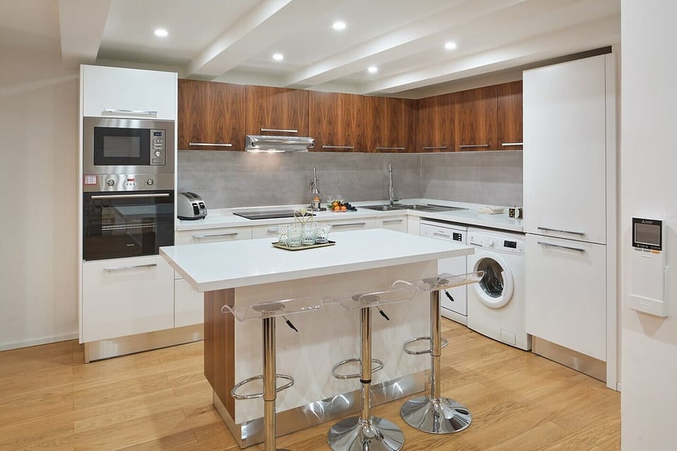The kitchen has a toaster, oven, microwave and washing machine.