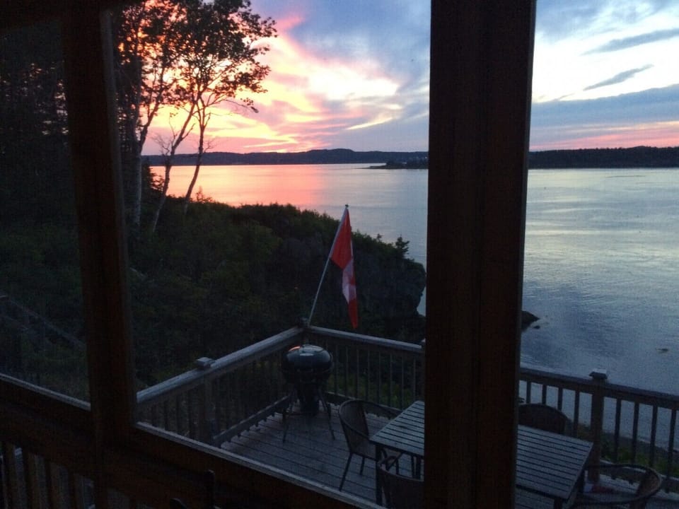 LARGER DECK WITH OUTDOOR DINING TABLE OVERLOOKING THE WATER