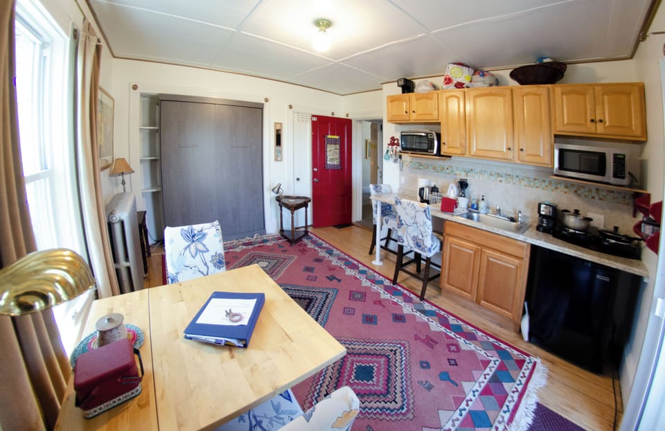 Main sitting room / kitchenette (bed is the grey panel on far wall).