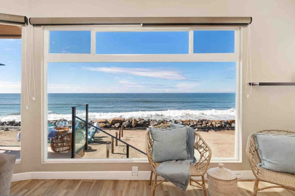 `Oceanfront living room with panoramic views and the sound of waves throughout the home.