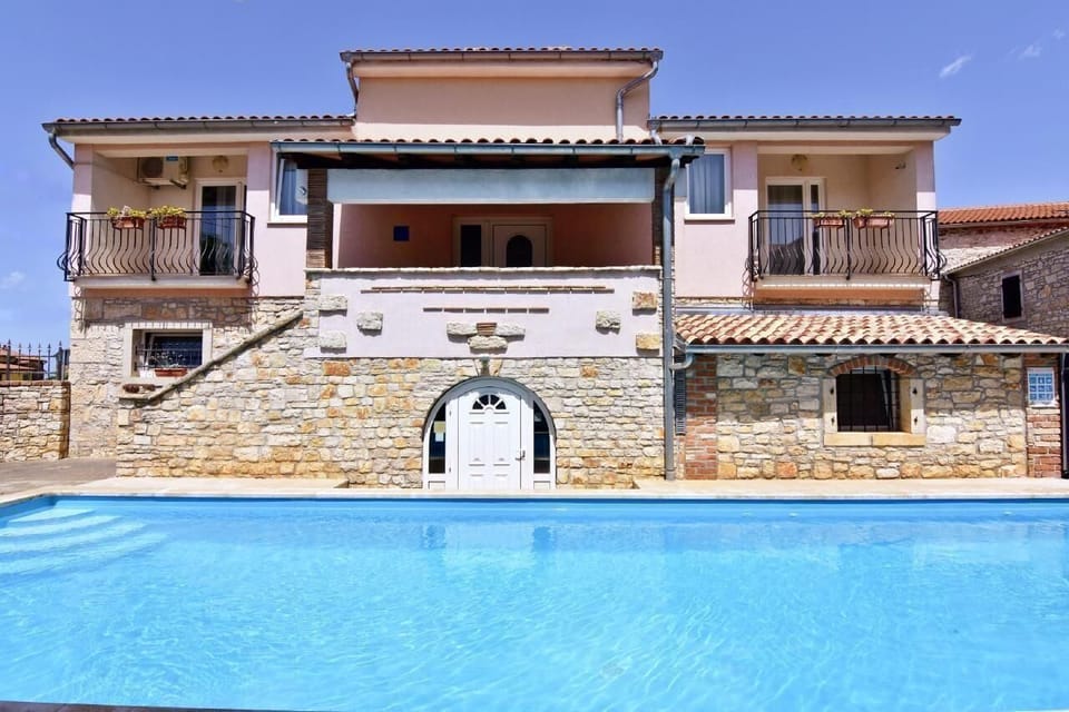 The front side of the house where the apartment is located and the splendid swimming pool