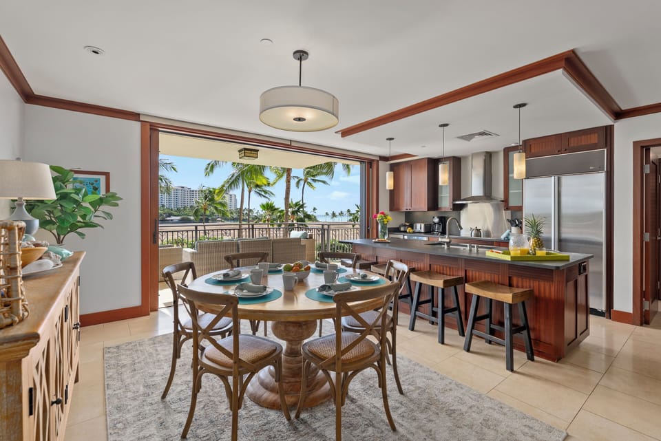 Open-concept kitchen and dining area that flows onto the lanai for indoor–outdoor living.