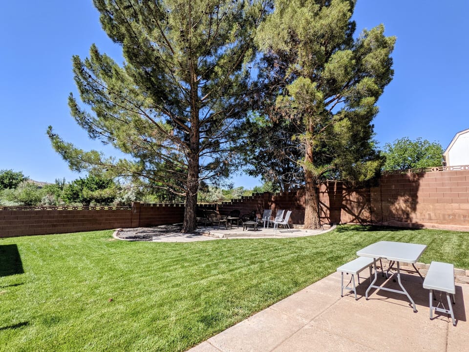 Side yard with picnic table & shaded sitting area w/ fire pit