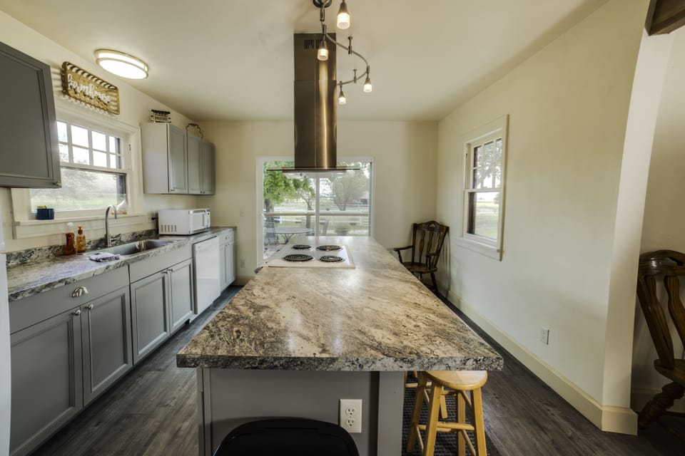 Bright kitchen with sliding glass door to front porch.