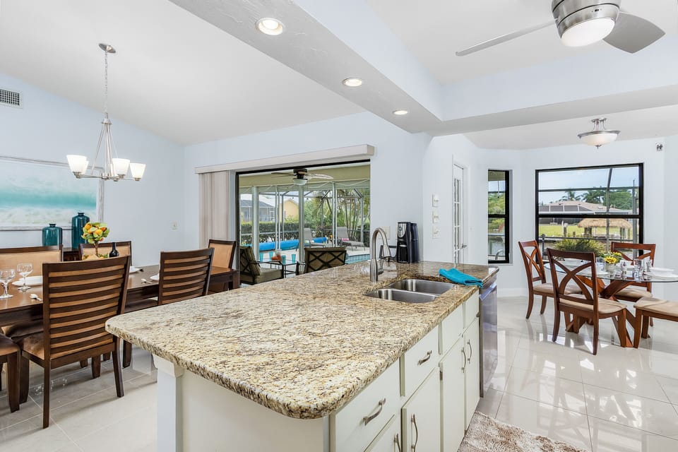 The kitchen island is between the kitchen & dining area