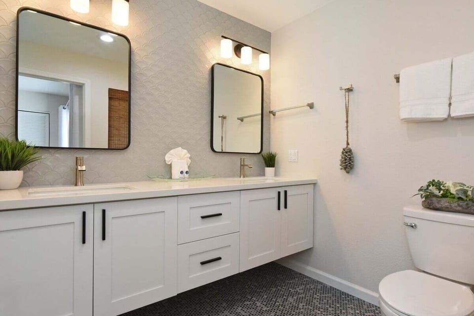 Beautifully updated bathroom with an expansive vanity, double mirrors, and soft modern lighting