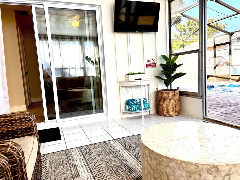 Enclosed patio TV area overlooking pool