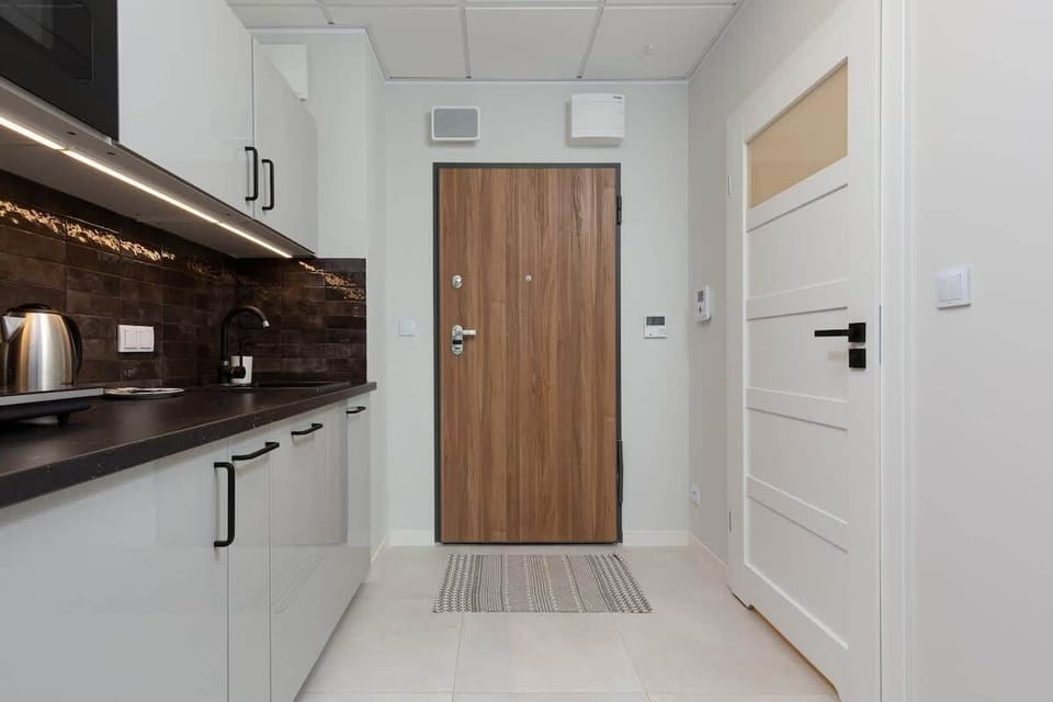 Functional kitchenette with white furniture and high-quality appliances,