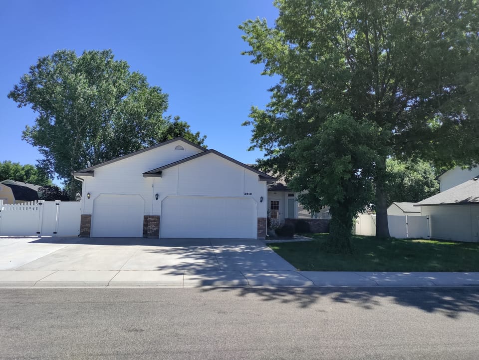 Front of the home with beautiful big trees and a huge driveway for parking multiple vehicles and even an RV