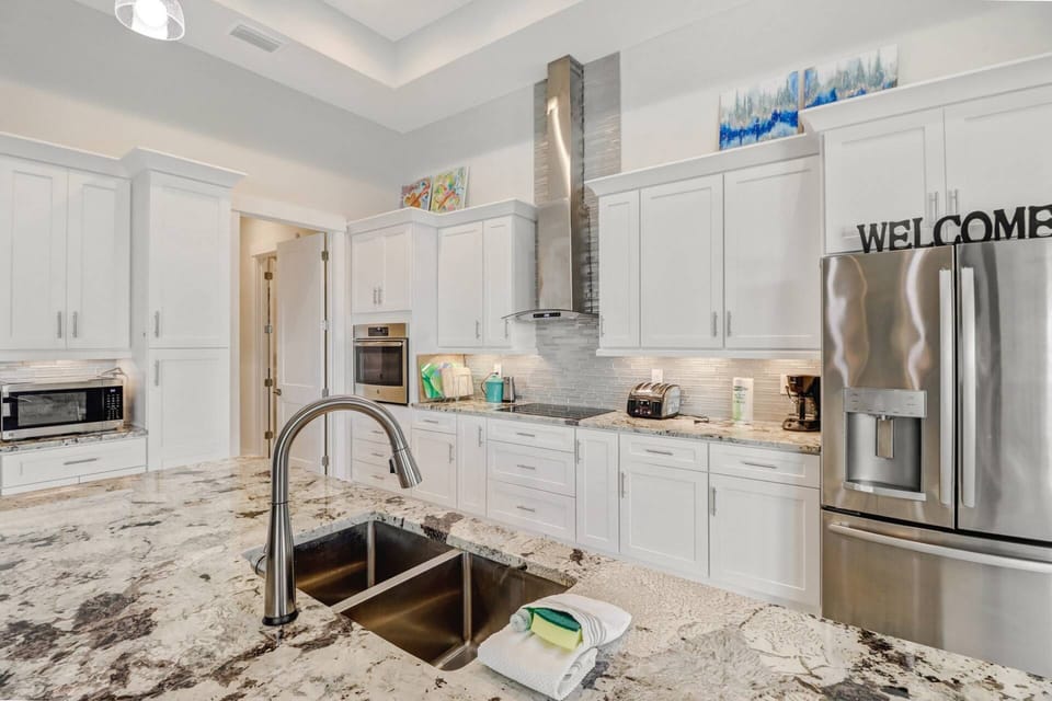 The kitchen is appointed with upgraded stainless appliances, granite counters, glass tile backsplash and abundant cabinets.