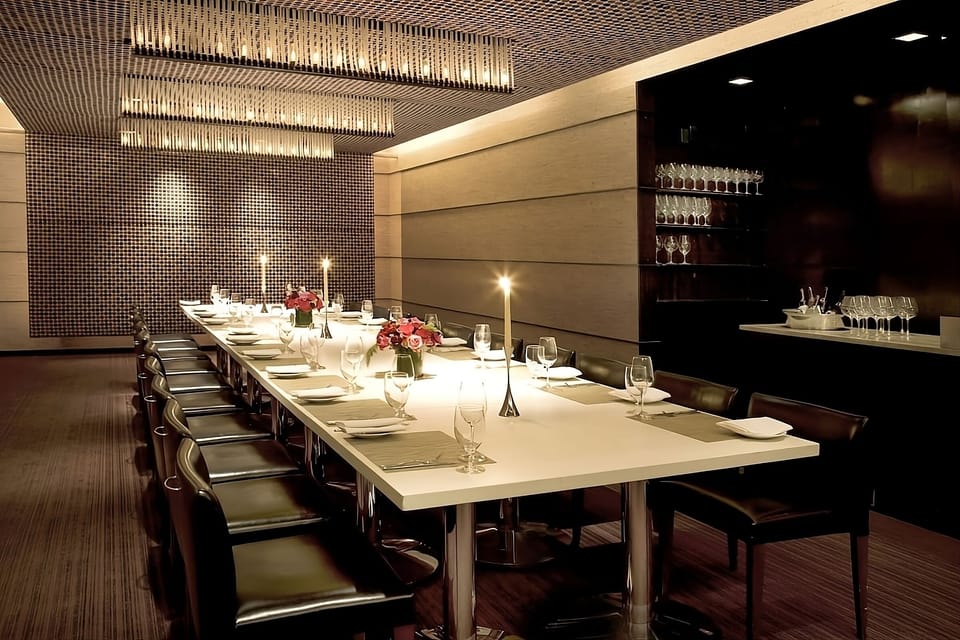 Gather for an intimate dinner under sparkling modern chandeliers.
