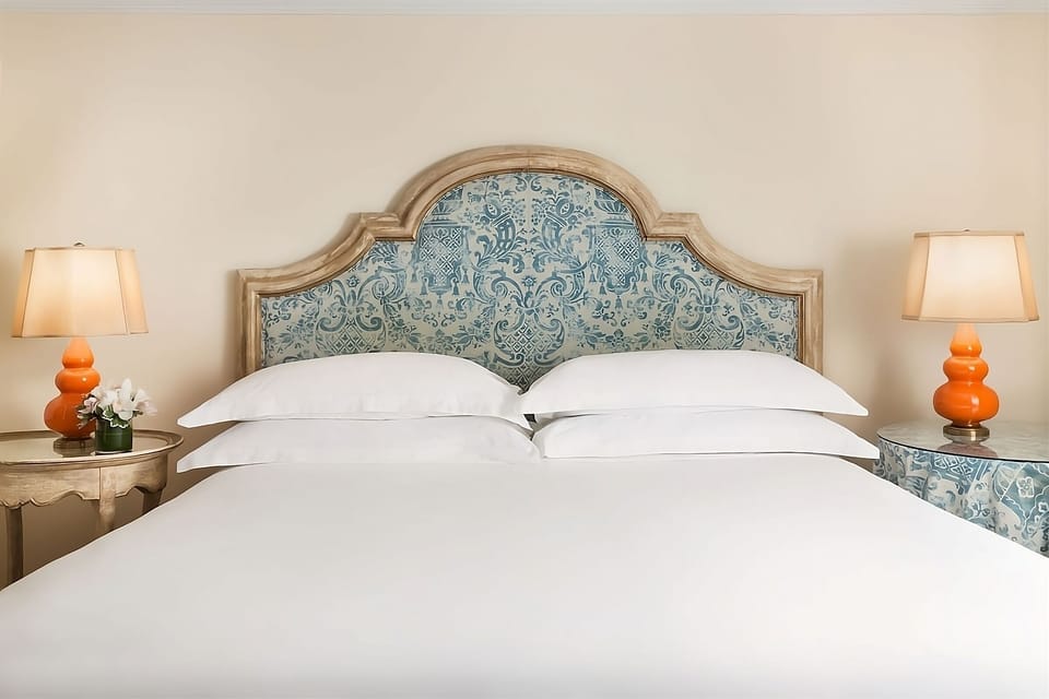 Drift off beneath crisp pillows and a charming patterned headboard.