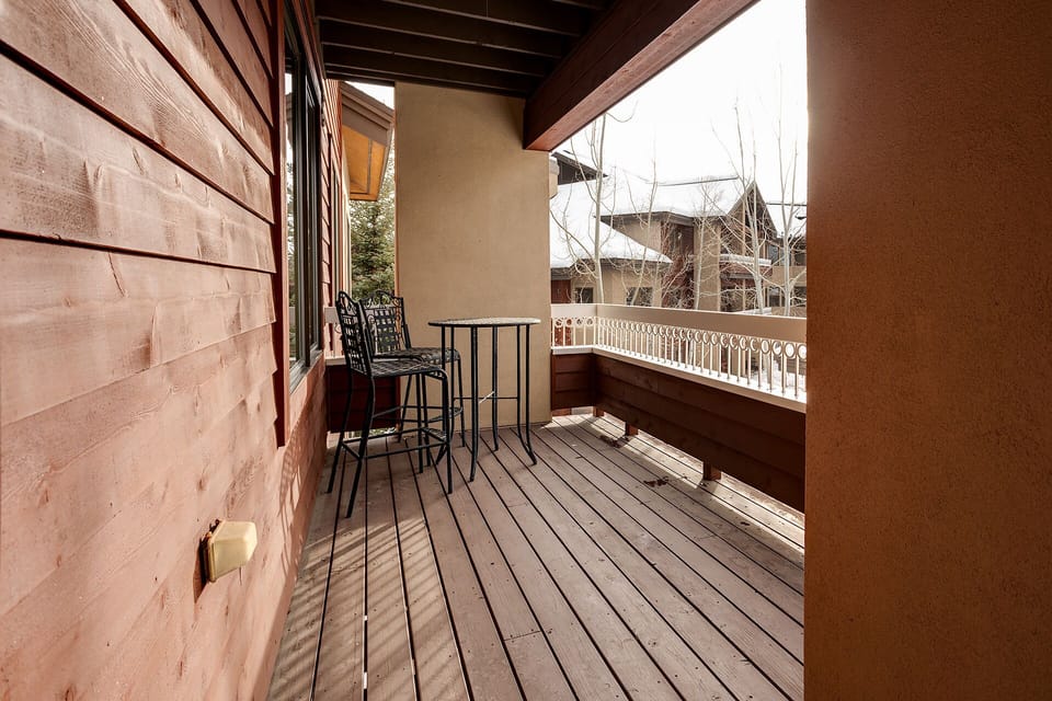 Enjoy your morning coffee on this charming wooden balcony, where natural light streams across the deck and mountain views create the perfect backdrop.