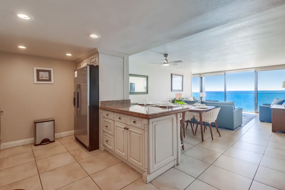 Open-style kitchen with breakfast bar that leads into the dining and living rooms areas