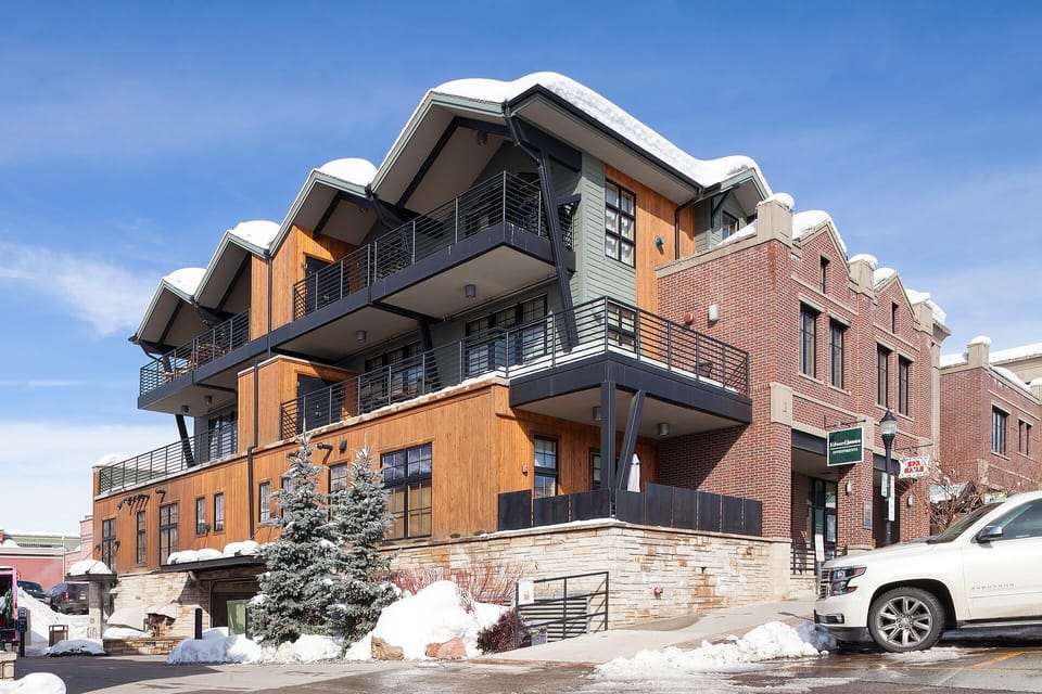 Modern mountain architecture with snow-dusted rooflines and stylish balconies creates an impressive winter backdrop for your alpine getaway.