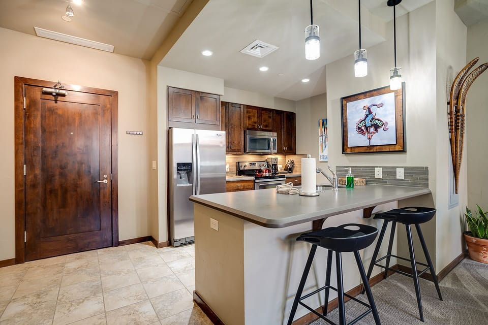 Your fully equipped kitchen awaits with stainless steel appliances, granite counters, and a breakfast bar perfect for morning coffee.