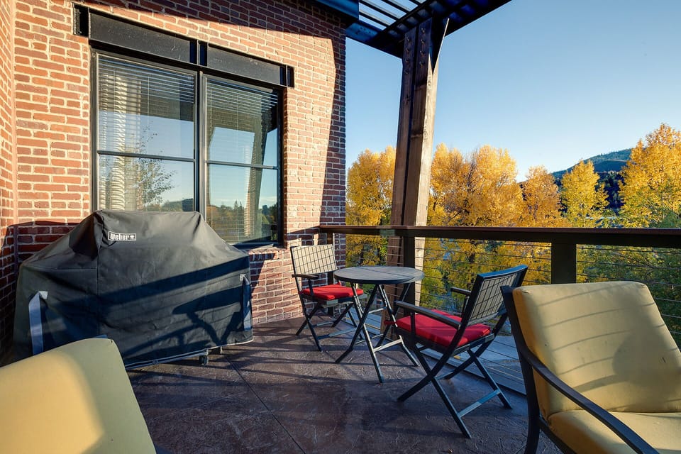 Savor autumn mornings on your private balcony with mountain views, complete with BBQ grill and cozy seating for memorable outdoor dining.