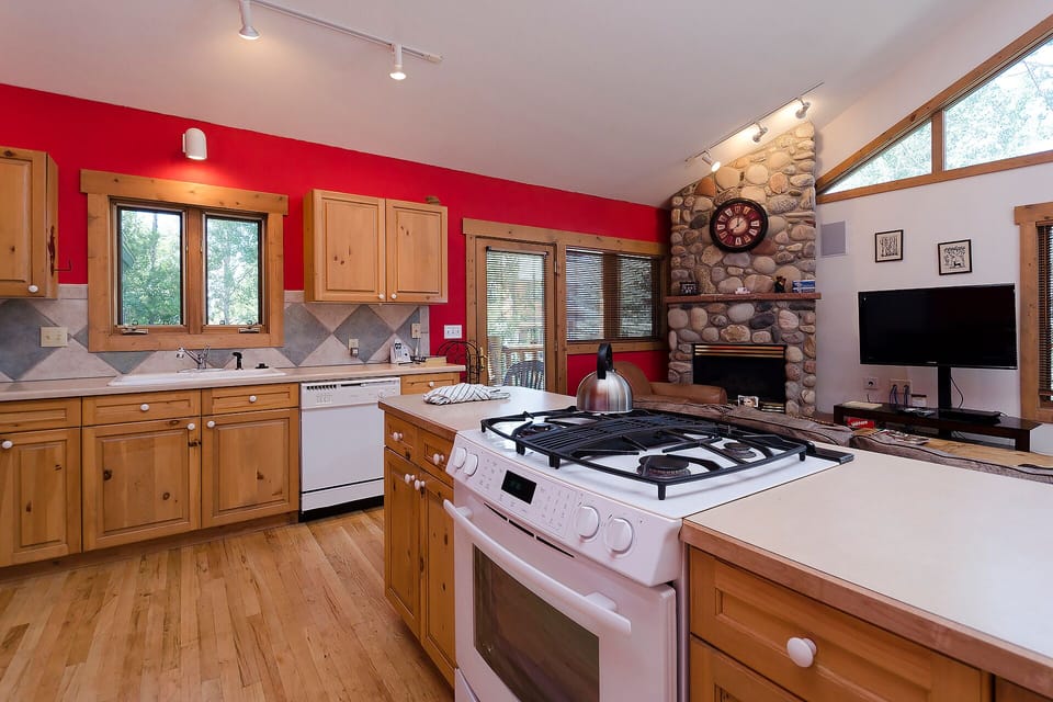 Cook memorable meals in your spacious kitchen featuring rich wood cabinets, granite counters, and a stunning stone fireplace backdrop for cozy evenings.
